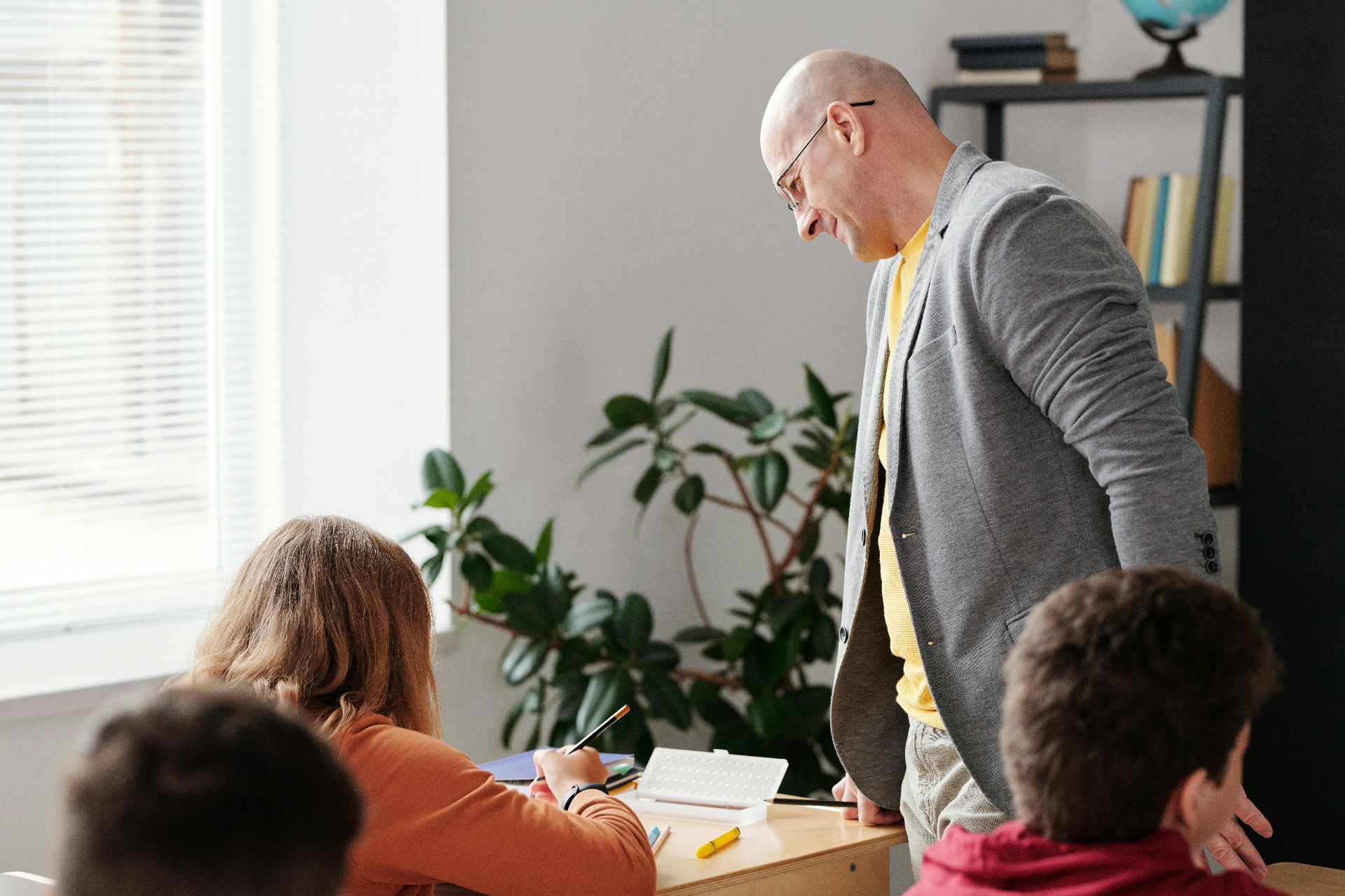 Lehrerin mit zwei Schülerinnen am Laptop